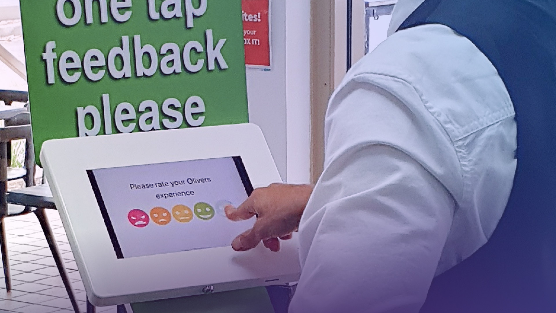 A person using one of OneTap's feedback kiosk in a restaurant